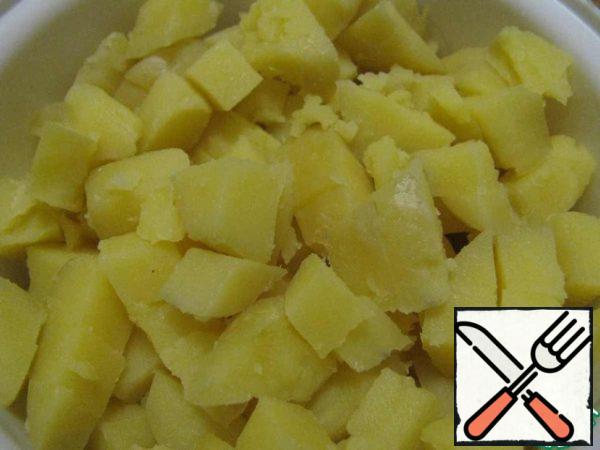 Boil the potatoes in salted water until tender. Drain the water. Cool the potatoes and cut them into cubes.
