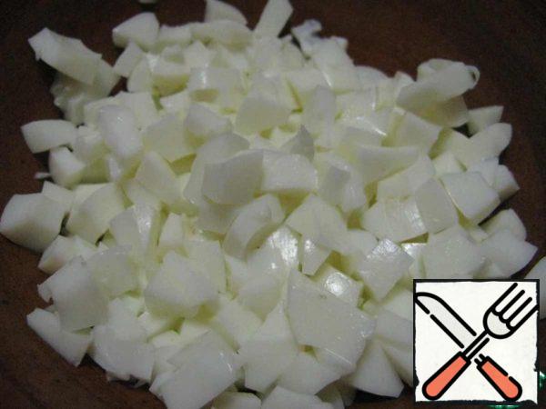 Peel the eggs, mix the yolks with the sauce, and cut the whites into cubes.
