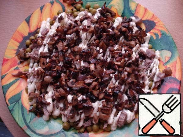 3rd layer: half of the fried mushrooms with onions, lubricate with mayonnaise.
