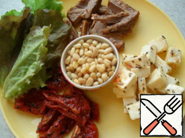 Prepare everything for our salad: cut tomatoes, meat and cheese.
I marinated cheese cubes in a sauce of vegetable oil, paprika, dried basil and garlic for 15 minutes. You can leave the cheese in this sauce for a longer time and store it closed in the refrigerator, and then use it in salads.