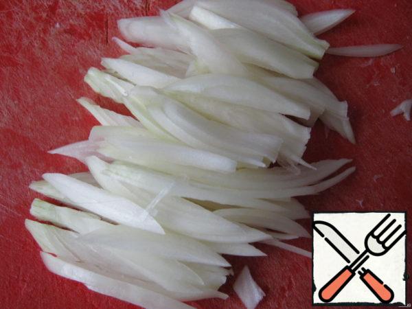 Cut the onion into thin strips. And fry it in preheated oil.

