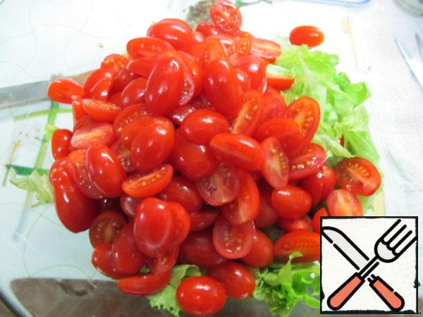 Now tear the salad and cut the cherry into halves. If the tomatoes are large, you can cut them into quarters.
