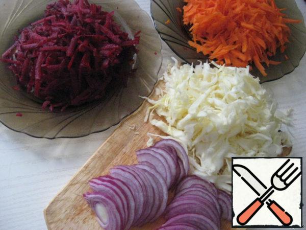 On a coarse grater, chop carrots, beets, cabbage, chop onions into half rings.
