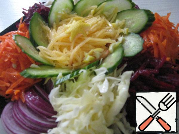 On the dish we spread all the chopped vegetables, sliced cucumber, and also lay out the petals for our salad - it turned out to be a flower with colorful petals.
