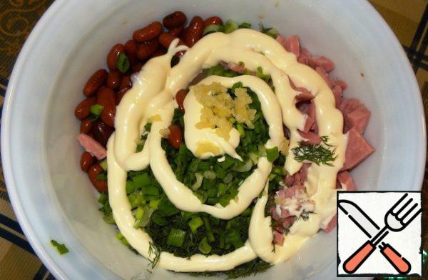 We wash the beans, cut the ham into cubes, chop the greens finely, pass the garlic through the press and put all this miracle in a salad bowl, fill with mayonnaise.

