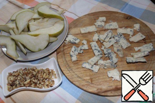 Cut the pear into slices. If the pear is very hard, it can be boiled in boiling water until soft.
Cut the cheese into thin (if possible) plates. I did it the only way, although you can just crumble it into a bag when you put it on a plate.
Fry walnuts in a dry frying pan and chop.
