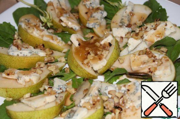 Wash the arugula, dry it and put it on a plate, put slices of pear and cheese on top, sprinkle with walnuts and pour the dressing.
The taste is very interesting. If you like the combination of blue cheese with fruits or berries, with a light wine-sweet taste of dressing, then this dish is for you.