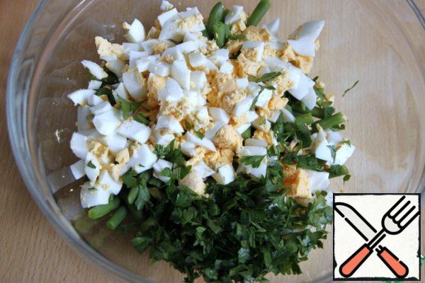 Cut boiled eggs into cubes. Parsley (3-4 sprigs) - chop. Add to the beans.

