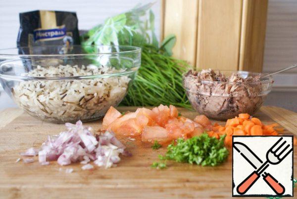While the pepper is blanching, finely chop the onion, carrot and parsley. Mash the tuna with a fork with a small amount of liquid from the jar. Finely chop the tomato, freeing it from the skin and seeds.
