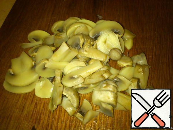 Boiled mushrooms cool and cut into thin plates.