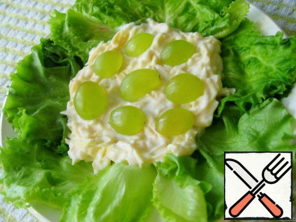 Put the washed and dried lettuce leaves on a plate, then cheese with yogurt and half a grape.
