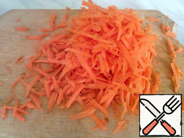 Grate carrots on a large grater.