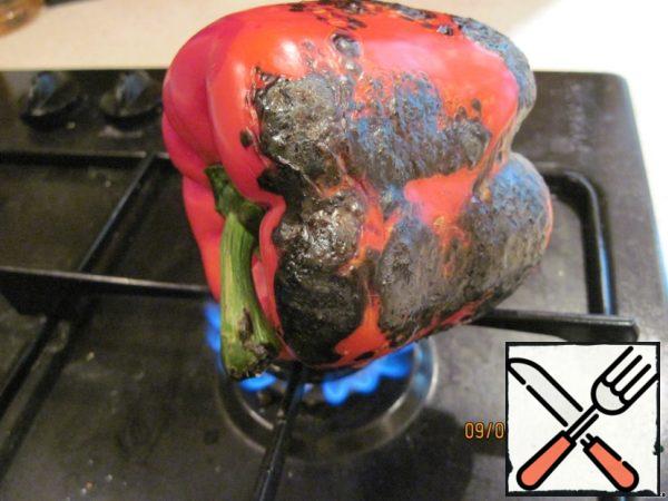 Pepper burn on the gas, until it is completely black. If the stove is electric, you can bake pepper in the oven.