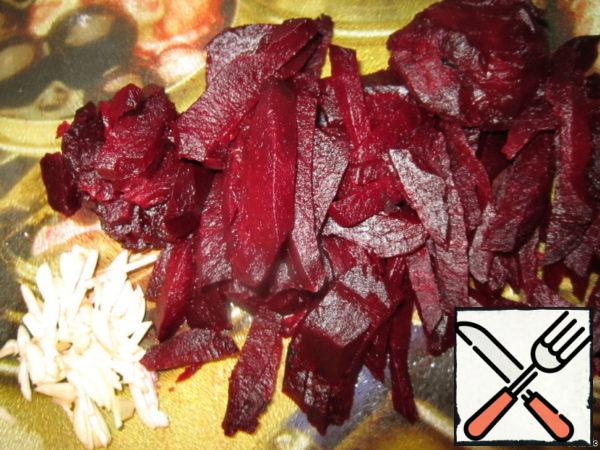 First we pickle the beets in advance.
Wash the beets, wrap in two layers of foil and bake in the oven until soft. At a temperature of 200 degrees. It takes about an hour.
Cool, peel and cut into strips. Garlic is also cut into strips and mixed with beets.
