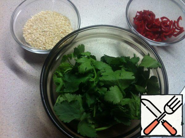 Preparation of the gas station. In the plate in which the salad will be served, grate the ginger root on the smallest grater (I take a block 2-3 cm long), remove the zest from a quarter of lime with the same grater. Add lime juice, sesame oil (for flavor) and olive oil (to compensate for the acid), and soy sauce instead of salt. Mix thoroughly and be sure to try for salt and acid.

Prepare some nice additions at the same time. Cut the coriander leaves from the stems, chop the chili (removing the seeds), fry the sesame seeds in a frying pan.
