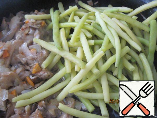 When the mushrooms are ready, put the boiled asparagus beans in a frying pan and fry together for a few minutes.
