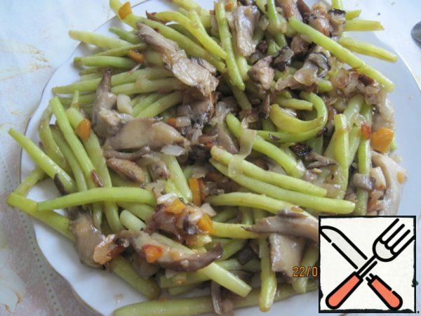 Put the fried mushrooms and green beans on a plate.
