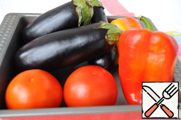 Pour quite a bit of water on a baking sheet. Prepare the vegetables for baking: prick the tomatoes with a fork and put them in the oven at 200 degrees, after 20 minutes remove the peppers and tomatoes, and leave the eggplants for another 15 minutes.
