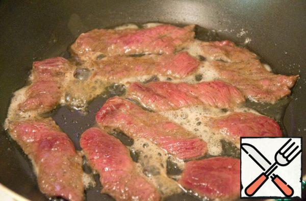 Fry the meat with a small amount of vegetable oil in a wok or in a frying pan until cooked. Since our pieces are very thin and soaked in marinade, it will take no more than 10 minutes.
