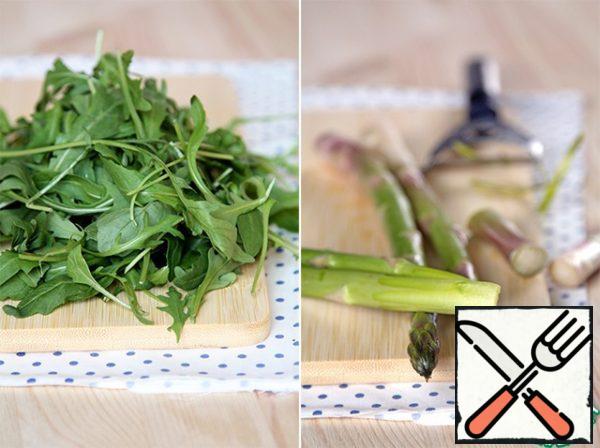 To begin with, we will get arugula and cook asparagus. To do this, wash the asparagus stalks, break off the dry and hard tips (to do this, bend each stem closer to the cut, the "bad" part will break off by itself), if necessary, peel the potato peeler on the broken end and send it to the steamer for baking. 7 minutes, then you need to rinse the stems under cold water and cut into pieces about 3 cm long. If the asparagus is thick, you can also cut it lengthwise into 2 or 4 pieces, at your discretion.
