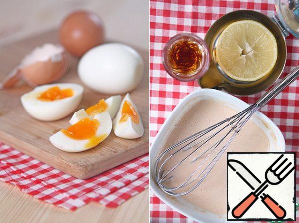 Boil the eggs and cut them into slices too. You can boil hard-boiled eggs, but I like it with a liquid middle, cook for 7 minutes.
From mayonnaise, ketchup, lemon juice and cognac, knead the sauce, add salt.
