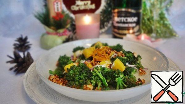 In the salad bowl, put first broccoli, then mango pieces, onion pieces, evenly distribute the caramelized nuts and pour on top of the resulting sauce. Decorate with orange peel.