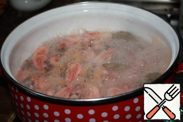 Boil the shrimp in salted water. I cook like this: for each liter of water I add 1.5-2 tablespoons of salt, 3-4 peas of coriander, 2 leaves of lavrushka. Water is poured at the rate of 1 kg of shrimp up to 2.5 liters. We throw the shrimps into well-boiled water, close the lid tightly until boiling and let it brew for 3 minutes. Remove the pan from the heat and leave them in the water for another 5 minutes. In my opinion, after this procedure, the meat becomes juicier.
Put the shrimps on a sieve for a few seconds and put them in cold water - this will make it easier to separate the meat from the shell.
Peeled shrimp cut lengthwise, if very small, then you can not cut at all)
