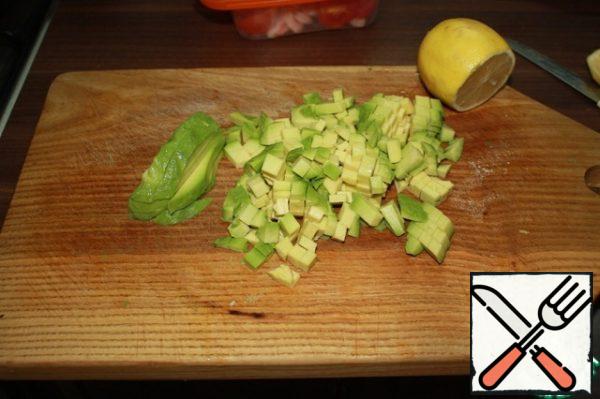 Remove the seeds from the avocado, peel it, cut it into cubes and immediately pour lemon juice liberally. If you do not do this, the fruits will quickly turn black and lose their beautiful appearance.
Mix all the ingredients, add salt to taste and season with sauce - mix the oil and lemon juice in a ratio of 3:1.