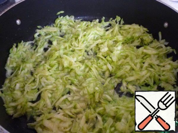 Pour olive oil into a deep frying pan, squeeze 1-2 cloves of garlic through a press. Put in the heated oil with garlic grated zucchini. Salt, mix and simmer for 5-7 minutes.