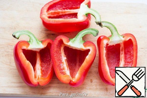 While the pasta is cooking, prepare the pepper. Wash the pepper, cut it lengthwise into two halves, including the stalk. Carefully cut with a knife at the base of the stalk and, while maintaining its integrity, remove the seeds and rough partitions.

