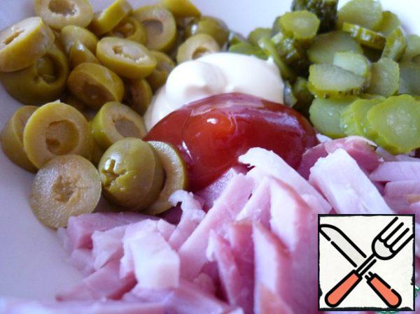 Chicken fillet cut into strips, cucumbers - thin slices, olives - rings. Mix everything and combine with mayonnaise and ketchup sauce.
