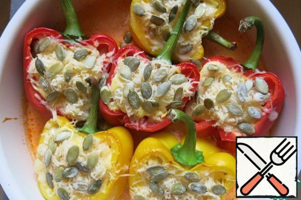 After 30 minutes, we take out our peppers, sprinkle with cheese and pumpkin seeds and send them to the oven for another 15 minutes
