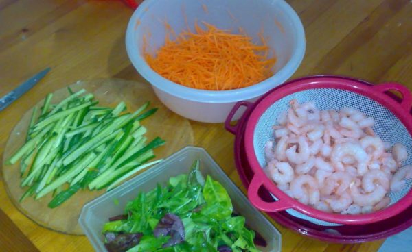 Boil the shrimps, peel them (I have them ready-made), grate the carrots, as for Korean carrots, or thinly slice them. Cucumbers - thin straws. Break the salad into pieces.
