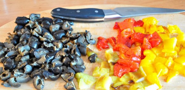 and cut into cubes, approximately 1x1 cm in size.
If the olives are pitted, cut into 2-3 pieces, if with a bone, press the olives with the flat side of the knife to squeeze out the bones, cut arbitrarily.