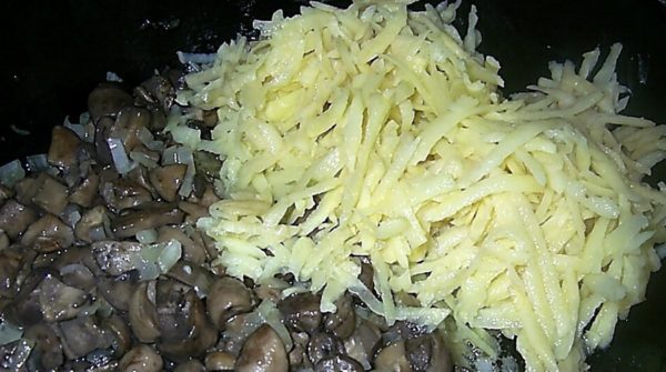 Add potatoes grated on a coarse grater to the mushrooms and fry until the potatoes are ready. Remove the pan from the stove.
