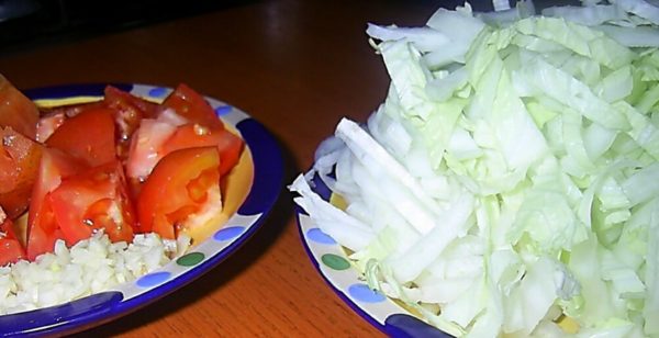 Chop the Peking cabbage, cut the tomatoes into pieces, chop the garlic with a knife.
