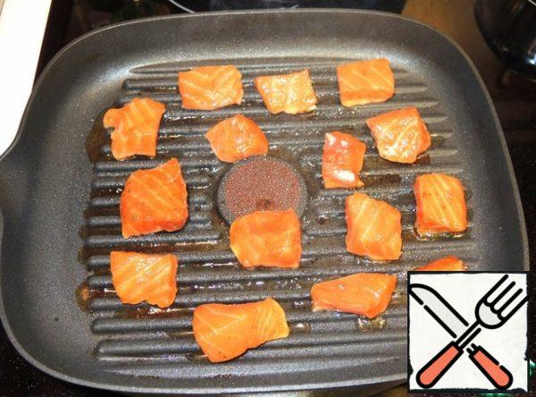 On a well-heated pan-grill fry the pieces of fish for literally 1 minute on each side. You do not need to add oil to the pan.