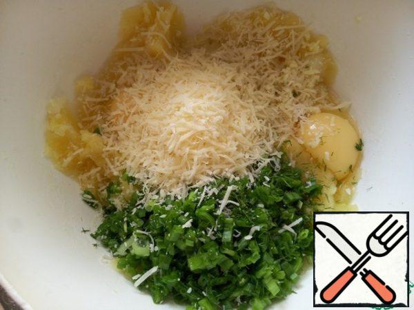 Season with salt and pepper, add eggs, grated parmesan, chopped garlic clove, chopped herbs and green onions.
