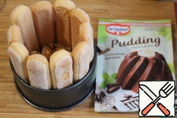 Place a split mold with a diameter of 12 cm sponge cookies on the edges, crumble the cookies on the bottom.
