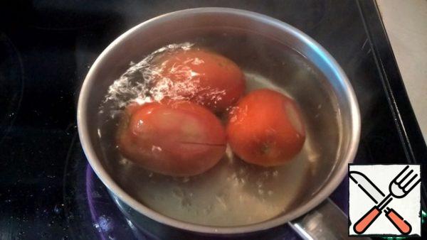Put it in boiling water for 1-2 minutes (so that the tomatoes do not boil).
