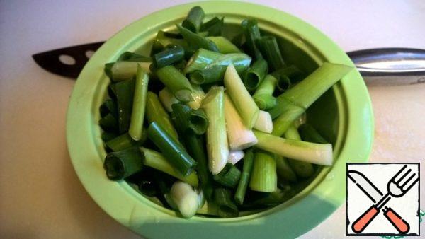 While the vegetables are being fried, cut the green onion into 3-5 cm pieces.
