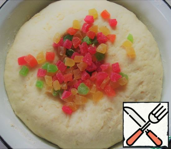 Add to risen dough candied fruits, obtinem it and knead it.