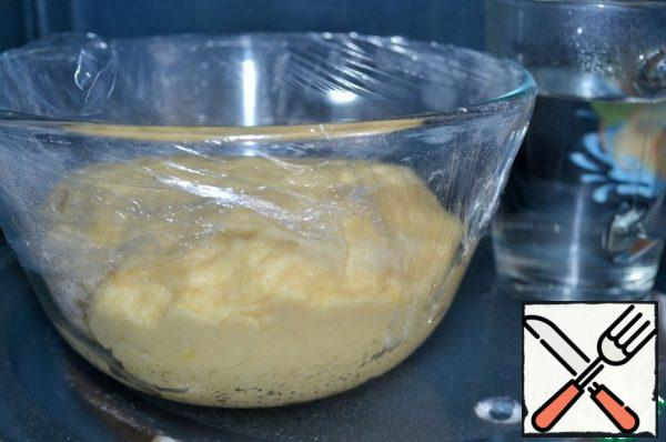 Place the wheat dough in a greased bowl.
Cover with plastic wrap and put in a warm, draft-free place for 1 hour,
for example in microwave, putting together a glass of boiling water.
At the same time the bread maker will do all these functions.