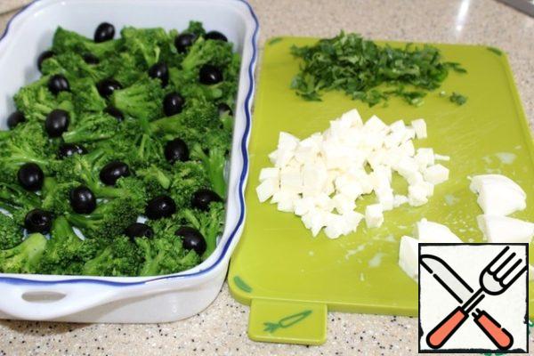 Grease a baking dish with butter, lay out the cabbage, spread olive oil on the surface, finely chop the parsley, divide a large ball of mozzarella in half, cut one part into small pieces, the other large.
The baking dish is 30 by 14 cm in size, if you take a smaller casserole dish, it will be indicated above.
