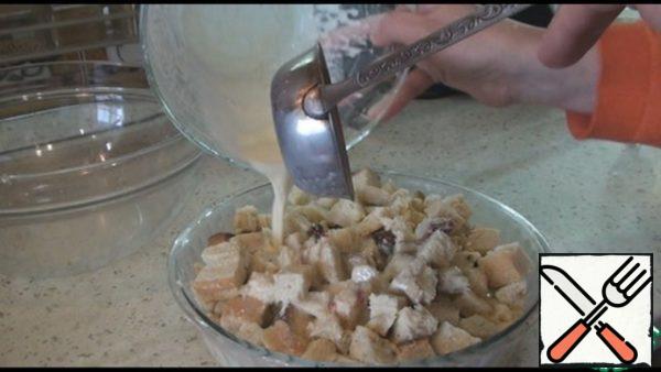 Grease the baking dish with butter, put the sliced cake and pour it with egg-cream mixture. Lightly press down with a spoon on top and leave for 3-15 minutes to soak it with liquid. The time depends on how dry your pie is.
