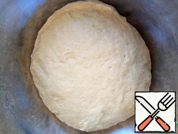 Then add the flour parts to the creamy egg mixture. And knead the dough. It should be smooth, elastic and obedient, slightly sticky to the hands. You can add a little more vegetable oil, knead, cover with a towel and put in a warm place to rise for about an hour.
