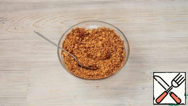 Pour the crumbs into the pan, add honey. Put the mixture on the stove and fry over medium heat. If the child starts to burn, the fire is reduced.
Stir occasionally and break the large lumps into crumbs. Fry the mixture until golden brown. Remove from the heat.
