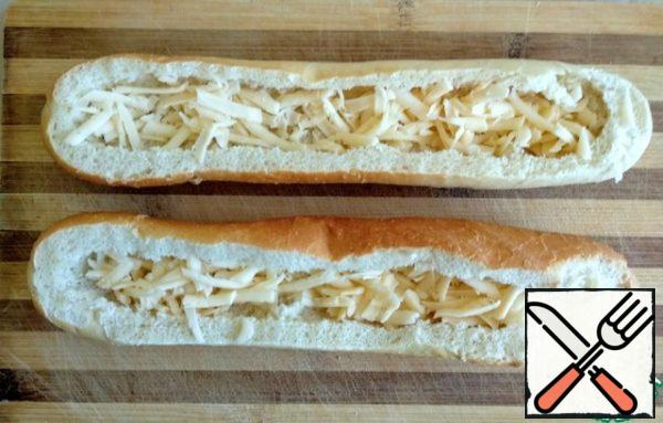 Grate the cheese on a coarse grater, put it in baguettes.
