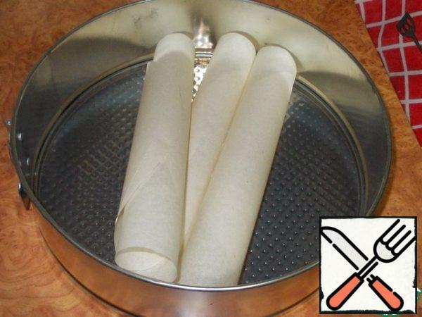 Prepare a baking dish for cakes. Cut out three circles from the parchment along the diameter of the bottom of our mold. The diameter of the mold is 26-27 cm .

