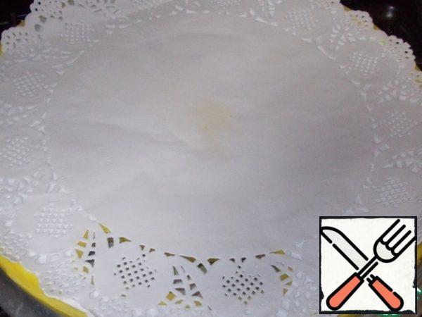Prepare the base to complete the cake. In my case, this is a round kitchen board, on which I put a drop of syrup, a thick paper napkin.
